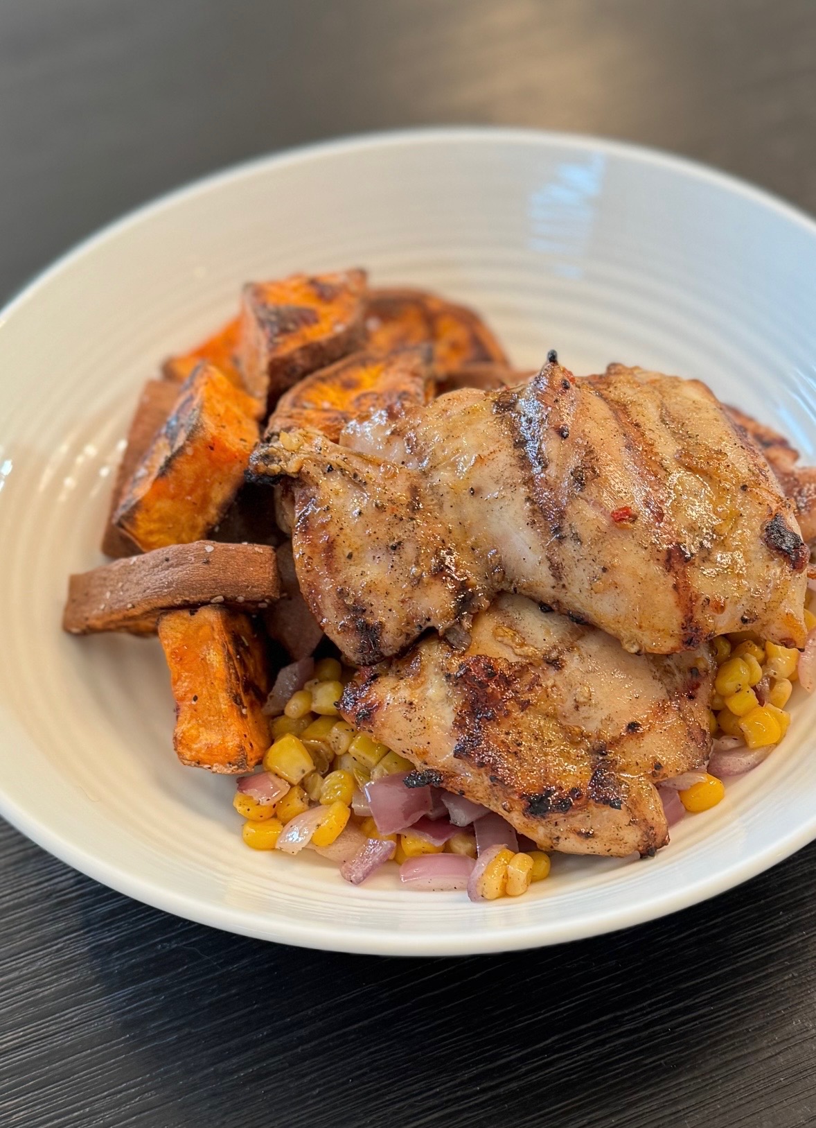 Maple Smoked Chicken” 6oz Maple Smoked Chicken Thigh served with Roasted Rosemary Sweet Potatoes & Sautéed Corn & Onions.